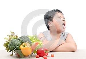 Boy with expression of disgust against vegetables