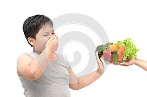 Boy with expression of disgust against vegetables