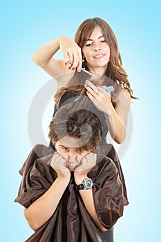 Boy with face expression with long hair at hairdresser