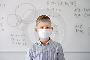 Boy with face mask back at school after covid-19 quarantine and lockdown.