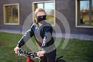 Boy in a face mask riding a bike