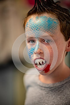 Boy with face painted like a shark