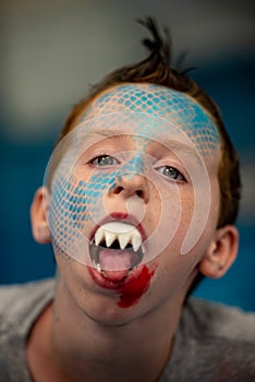 Boy with face painted like a shark