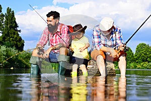 Boy with father and grandfather fly fishing outdoor over river background. Young - adult concept. Old and young. Little