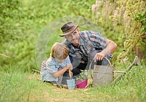 Boy and father in nature with watering can. Gardening tools. Planting flowers. Dad teaching little son care plants