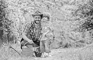 Boy and father in nature with watering can. Spring garden. Dad teaching little son care plants. Little helper in garden