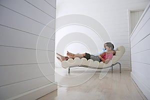 Boy With Father Reclining On Lounge Chair