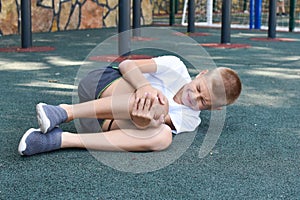 Boy fell and hit on outdoor playground. knee injury child sports injury
