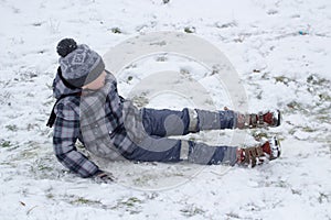 Boy fell on snow,boy slipped on the ice and fell into the snow