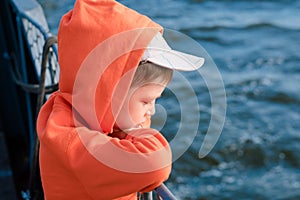 The boy on the ferry looks at the sea. Ferry travel. portrait of a boy against the background of the blue sea. Calm looking at the