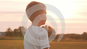 Boy in a field at sunset. The concept of childhood, freedom and inspiration.