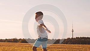 Boy in a field at sunset. The concept of childhood, freedom and inspiration.