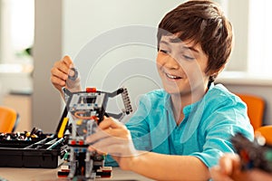 Boy finishing his work on the complicated robot.