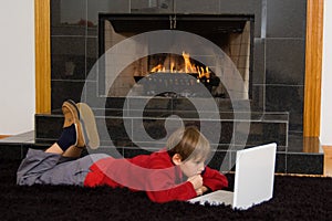 Boy at Fireplace on Computer.