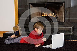 Boy at Fireplace on Computer.
