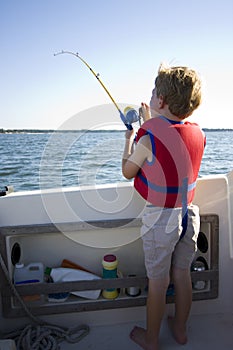 Boy fishing from a boat.