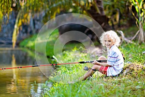 Boy fishing. Child with rod catching fish in river