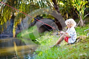 Boy fishing. Child with rod catching fish in river