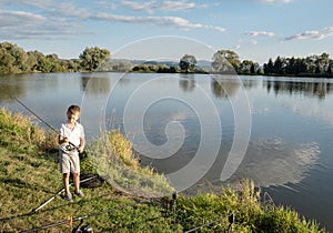 Chlapec rybaření na jezeře. Krásný rybník v Badíně, nedaleko Banské Bystrice, Slovensko. Rybářské místo. Zářící slunce nad rybníkem