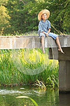 Boy during fishing with rod on bridge