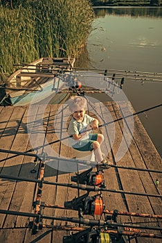 Boy with fishing rod catching fish in the summer