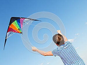 Boy flies kite into blue sky