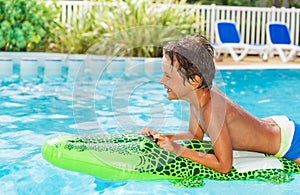 Boy floating on inflatable toy in swimming pool