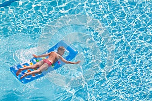 A boy floats on an inflatable colored mattress