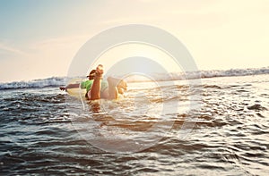 Boy floats on surf board. Beginner surfer, first lessons