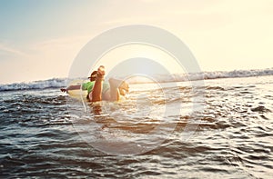 Boy floats on surf board. Beginner surfer, first lessons photo