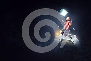 Boy flying with huge computer