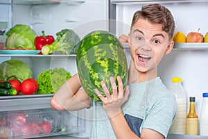 Boy with food near fridge