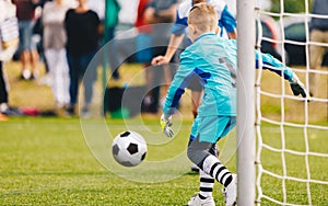 Boy Football Goalie in Action. Young Soccer Goalkeeper Running Towards Soccer Ball