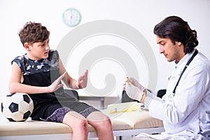 Boy football player visiting young doctor traumatologist