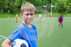 Boy footballer with a ball in a stadium