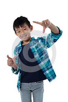 Boy forming a finger frame against white background