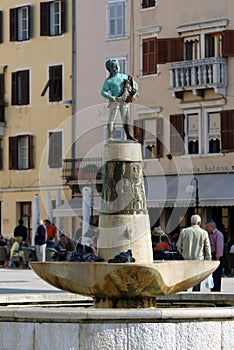 Boy fountain with a fish statue in Rovinj, Croatia