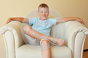 Boy freely sitting with magnificent easy chair photo