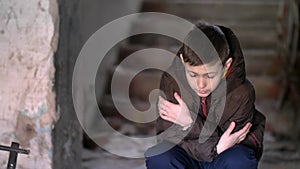 Boy freezing in warm clothing in a dilapidated old house