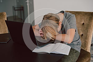 boy get tired from online study at home, he lied down his lied on the desk and have a nap