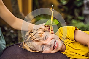 The boy gets a procedure with an ear candle, children`s ears health, good hearing, earwax