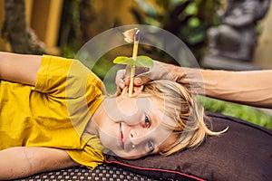 The boy gets a procedure with an ear candle, children`s ears health, good hearing, earwax