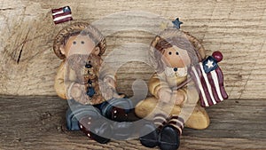 Boy and girl with american flags on wood background