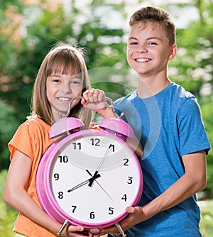 Boy and girl with big clock
