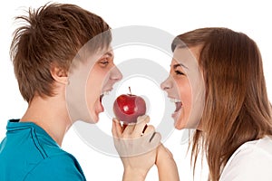 Boy and a girl biting the apple