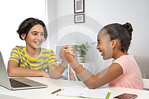 A boy and a girl during a break from classes compete in arm wrestling