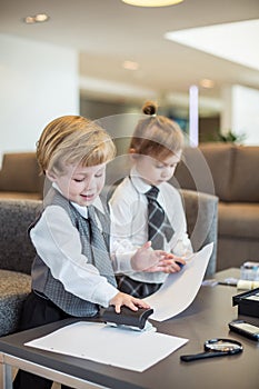 Boy and girl in business suit playing with