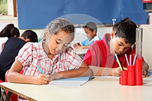 Boy and girl in classroom concentrating on lesson