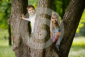 Boy and girl climb big tree