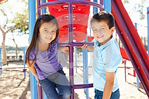 Boy And Girl On Climbing Frame In Park